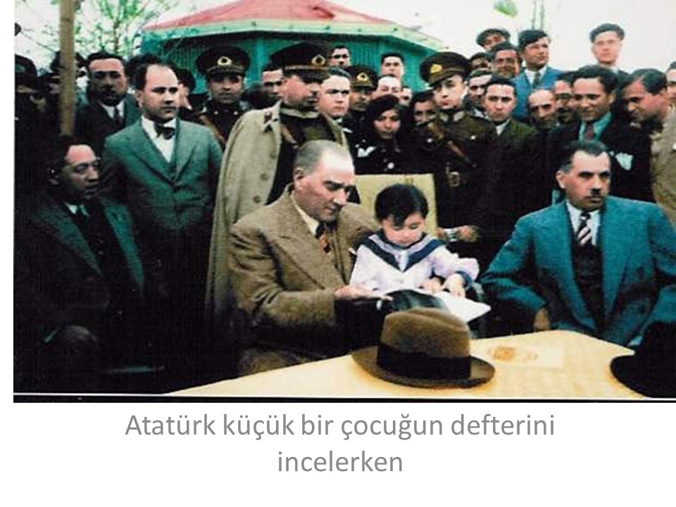 Atatürk küçük bir çocuğun defterini incelerken